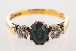 An 18ct gold sapphire and diamond ring, set with an oval-cut dark green to blue sapphire,