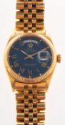 WITHDRAWN Rolex an 18k gold wristwatch the blue dial having raised Roman numerals,