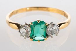 An emerald and diamond three stone ring, set to the centre with a rectangular-cut emerald, approx.