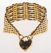 A wide gate bracelet, with heart padlock and safety chain, partial UK hallmark, tests as 9ct,