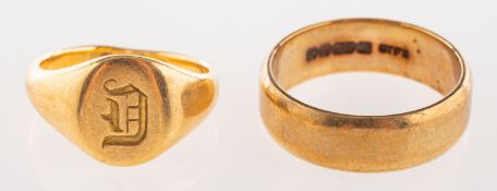 A group of two gold rings, including an 18ct yellow gold signet ring with engraved initial,