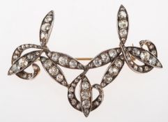 A Victorian diamond set brooch/pendant, of scroll form and set with old-cut diamonds,