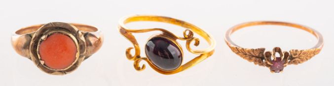 A group of three antique rings, including a flowerhead ring set with a coral cabochon,
