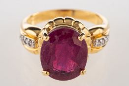 An 18ct gold ruby and diamond ring, claw set with an oval-cut ruby, approx. 4.