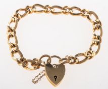 A 9ct yellow gold curb link bracelet, with heart padlock and safety chain, UK hallmark,