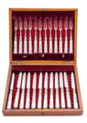 A cased set of twelve mother of pearl and silver plated dessert knives and forks, with silver bands,
