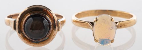 A group of two rings, including a ring set with an oval-cut opal cabochon, unmarked & untested,