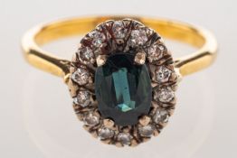 A sapphire and diamond cluster ring, set with an oval-cut green to blue sapphire, sapphire approx.