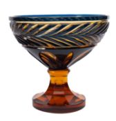 An amber and blue flashed pedestal bowl with cut decoration, 25cm diameter.