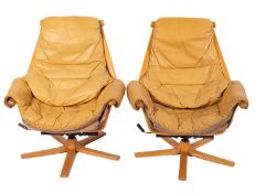 A pair of modern Swedish leather and beech laminate swivel reclining chairs,