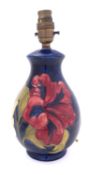 A Walter Moorcroft pottery lamp base, tube lined in the Hibiscus pattern,