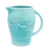 A Susie Cooper pottery jug moulded with flowers and foliage on a matt green ground,