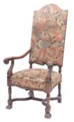 A carved walnut and upholstered elbow ch