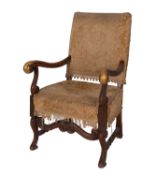 A carved walnut and upholstered elbow ch