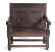 A 17th Century and later oak settle, of small size, the rectangular back with moulded top rail,
