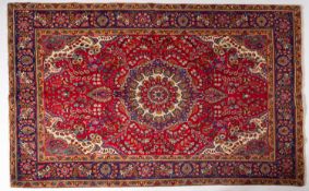 A Tabriz carpet, the madder cartouche field with a central indigo,