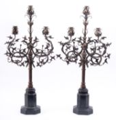 A pair of metal three light candelabra in Gothic taste,