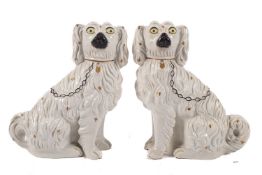 A pair of Staffordshire comforter spaniels, each modelled with independent leg with painted details,