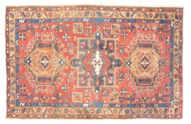 A Heriz rug, the wine field with triple geometric hooked and shaped medallions,