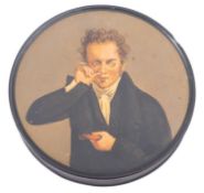 A mid 19th century Continental papier mache snuff box and cover painted with a gentleman taking