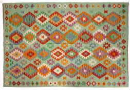 An Anatolian Turkish Kelim, the pastel green field with a design of serrated and lozenge medallions,