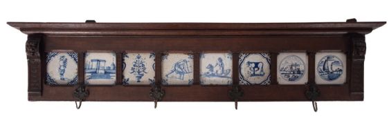 A carved oak Delft tile mounted coat hook panel, 19th century construction,