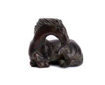 A Chinese bronze scroll/paper weight in the form of a reclining horse,