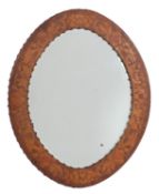 An oval leather framed wall mirror, probably Spanish,
