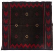 A Belouchistan kelim, the dark field with nine hooked medallions, enclosed by chevron guard stripes,