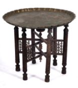 An Islamic, probably north African brass tray topped table, circa 1900; of circular form,