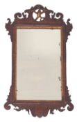 A walnut and parcel gilt framed wall mirror in George II style,