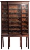 A George III mahogany and glazed breakfront bookcase on stand,