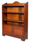 A 1920's oak open bookcase, with a shaped three quarter gallery and adjustable shelves,
