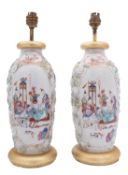 A pair of Chinese famille rose moulded vases painted with cartouches of family groups in interiors