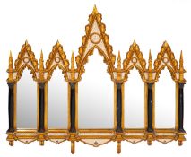 A carved, painted and parcel gilt framed wall mirror, in Gothic style,