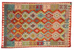 An Anatolian Turkish Kelim, the brightly coloured field with a design of stepped lozenges in lilac,