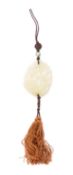 A Chinese celadon jade pendant carved and pierced with a duck amongst flowering lotus, 5.5 x 4cm.