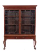 A late 19th Century mahogany bookcase on a stand, the upper part with a moulded cornice,