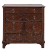 A 17th Century oak rectangular chest, containing four long geometrically moulded panel drawers,