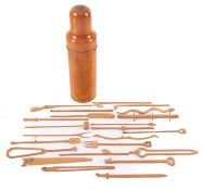 A collection of Spillikins, in a fruitwood bottle-shaped case, 14.5cm high.