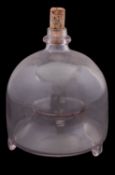 A plain glass wasp trap, of bell shape with cork stopper and tripod stub feet, 15cm diameter.