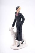 A German Art Deco pottery figure of an elegant lady walking with her Borzoi,