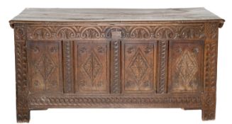 An early 18th Century and later carved oak rectangular coffer, with a plain hinged top,