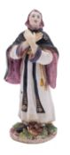 A Bow figure of a nun modelled standing with hands crossed and wearing habit and veil,