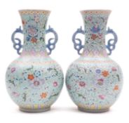 A pair of Chinese famille rose baluster vases with dragon handles, painted with lotus, peony,