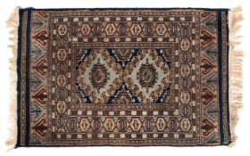 An Afghan Turkoman rug, the brick red geometric field with twin stellar medallions,