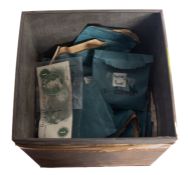 An old tin containing a quantity of world coinage in old bank bags.