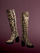 A pair of 1970s knee high platform heeled boots with a dark brown and cream spotty design,