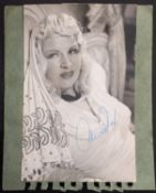 Mae West (1893-1980) A signed postcard portrait mounted on green card.