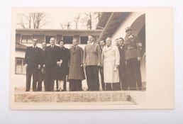 A photographic postcard of HRH Duke of Windsor and Wallace Simpson beside Adolph Hitler and other